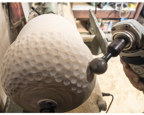 Drechselarbeit mit einem Holzbearbeitungswerkzeug in einer Werkstatt