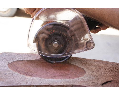 Eine Person verwendet eine Flex zum Bearbeiten eines Holzstücks.