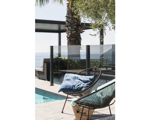 Espace extérieur avec piscine, mobilier de salon et deux fauteuils en rotin avec coussins