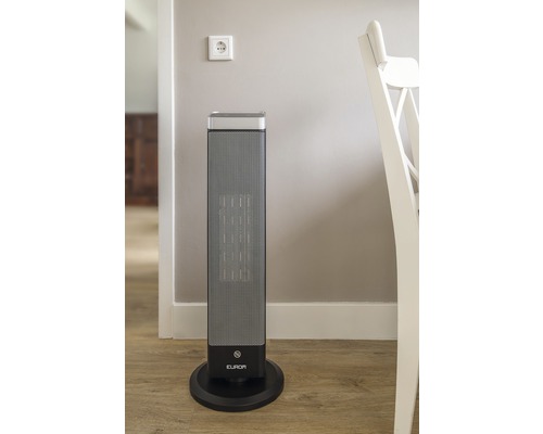 Radiateur électrique sur pied sur un plancher en bois à côté d''une prise de courant