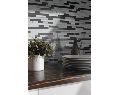 Mur de carreaux de mosaïque au-dessus d''un comptoir de cuisine avec de la vaisselle et de la décoration