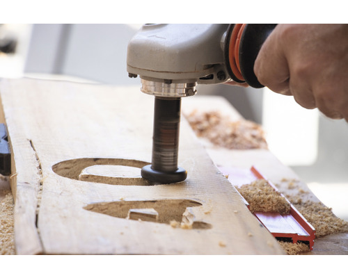 Handwerker bearbeitet Holz mit einem Winkelschleifer