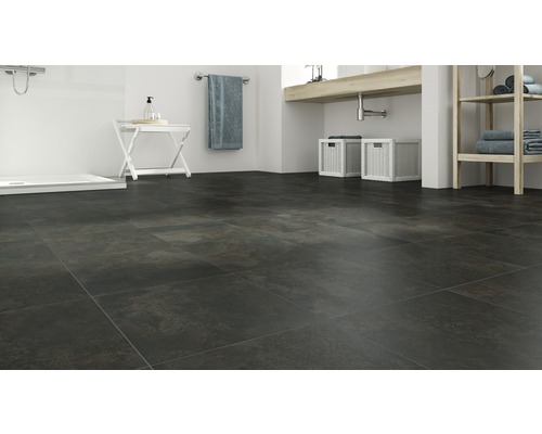 Badezimmer mit dunklen Bodenfliesen, Waschtisch und Dusche.