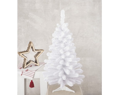 Weißer künstlicher Weihnachtsbaum auf einem Ständer neben einem Holzstern