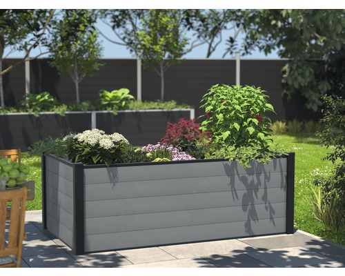 Jardinière surélevée en plastique avec plantes dans le jardin.