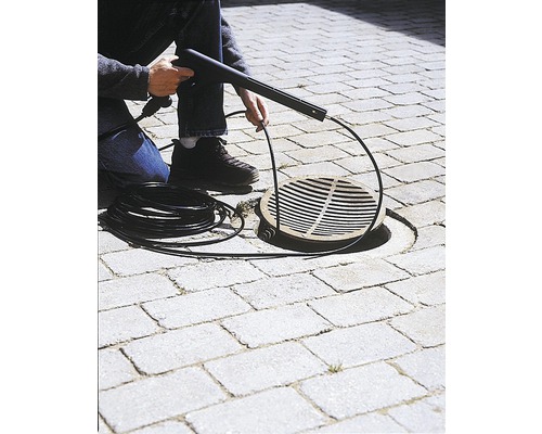 Nettoyeur de canalisations en cours d''utilisation sur des pavés