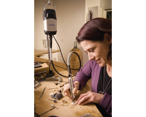 Femme travaillant avec un outil multifonction Dremel sur une table