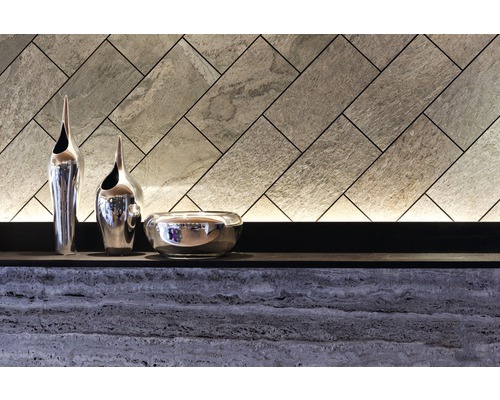 Dekorative Wandgestaltung mit Steinpaneelen und silbernen Vasen