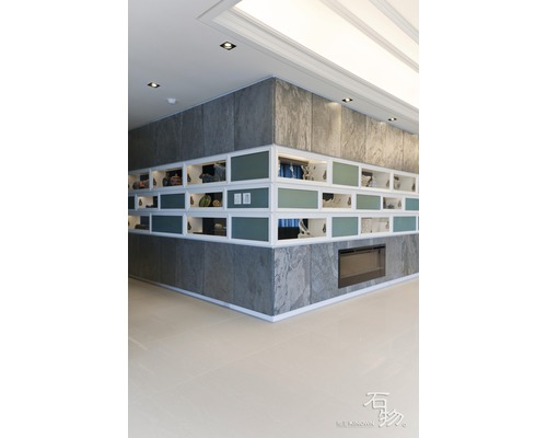 Innenraum mit Wandpaneelen in Steinoptik, weißen Regalen und Kamin