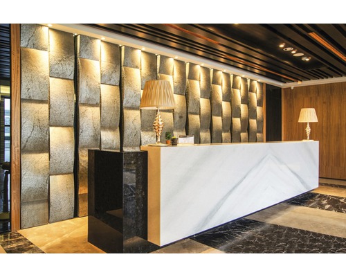 Empfangsbereich mit strukturierten Wandpaneelen aus Stein, Rezeptionstisch mit Marmoroptik und Lampen