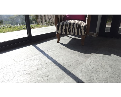 Bodenbelag mit grauen Natursteinplatten auf Terrasse mit Sessel