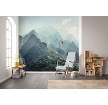 Salon avec papier peint photo paysage de montagne, fauteuil, lampe et étagère en bois