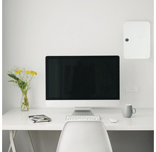 Espace de travail avec ordinateur, bureau et tableau électrique apparent