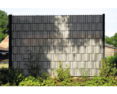 Clôture de confidentialité en plastique avec éléments métalliques dans le jardin