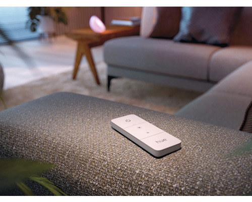 Télécommande Philips Hue sur un tabouret dans un salon