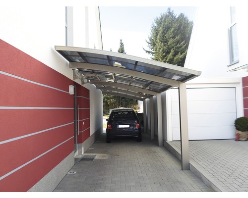 Voiture sous un abri de voiture à côté d''une maison avec garage
