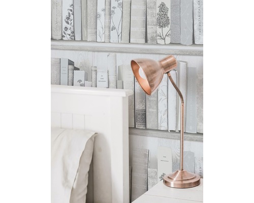 Scène décorative avec un lit, une lampe et un papier peint imitant une bibliothèque.