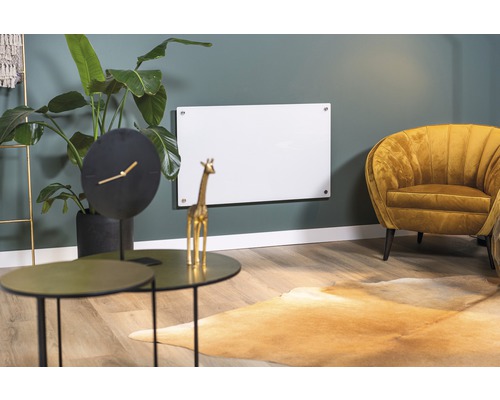 Wohnzimmer mit Infrarotheizung an der Wand, Tisch, Uhr und Sessel