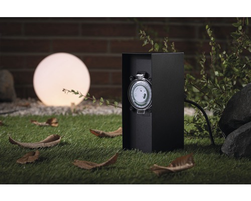 Minuteur d''extérieur à côté d''une lampe sphérique dans le jardin.