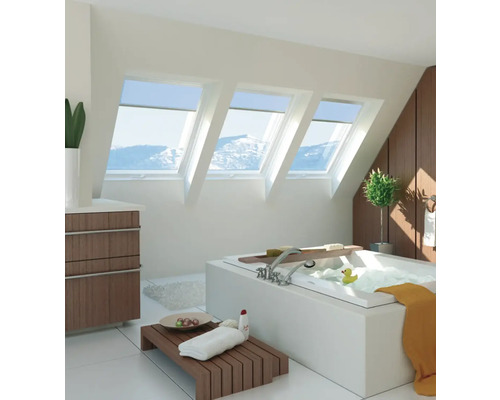 Salle de bain lumineuse avec fenêtres de toit, baignoire et détails en bois