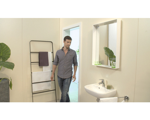 Badezimmer mit Waschbecken, Spiegel, Handtuchhalter und Mann