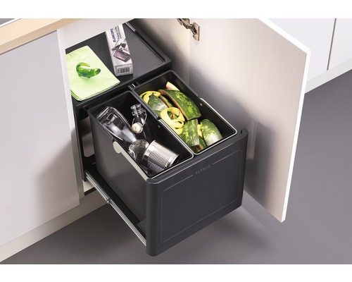 Mülltrennsystem im Küchenschrank mit zwei Behältern gefüllt mit Abfall.