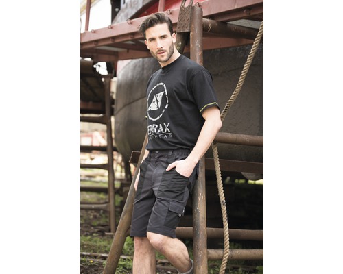 Mann trägt eine schwarze Arbeitshose und ein T-Shirt von Terrax Workwear