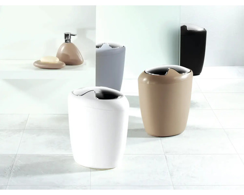 Plusieurs poubelles de salle de bains et accessoires de salle de bains sur un sol carrelé.