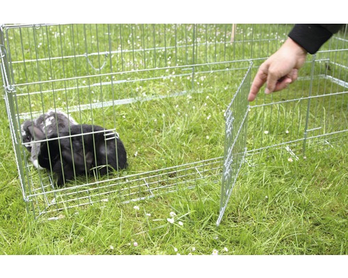 Enclos extérieur en métal avec lapin dans un pré