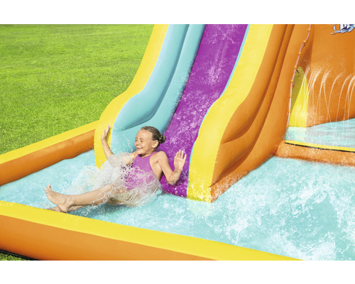 Mädchen rutscht auf einer aufblasbaren Wasserrutsche in einem Garten