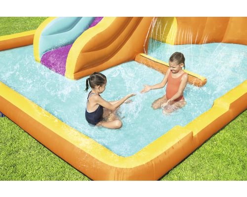 Aufblasbare Wasserrutsche mit Pool und spielenden Kindern