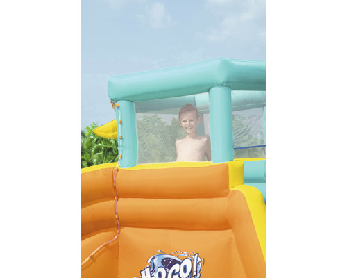 Aufblasbare Wasserrutsche mit spielendem Kind im Sichtfenster