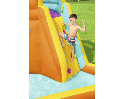Junge klettert auf eine aufblasbare Wasserrutsche im Garten