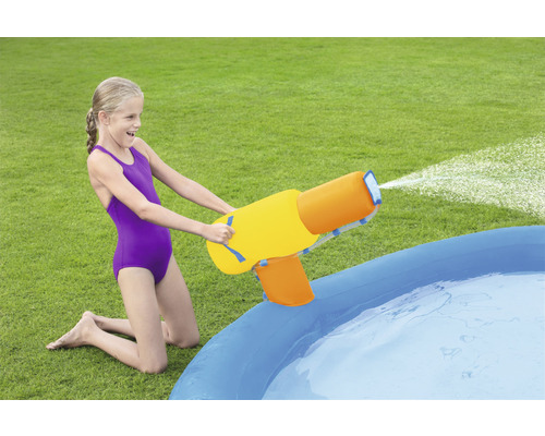 Mädchen mit Wasserpistole am Planschbecken im Garten
