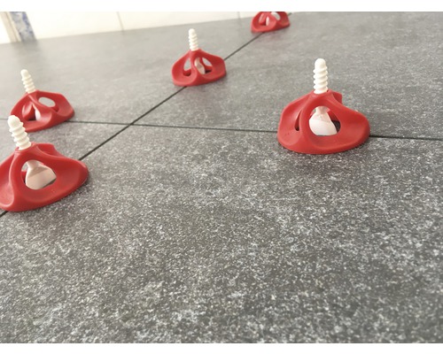 Système de nivellement de carreaux avec éléments filetés sur sol carrelé