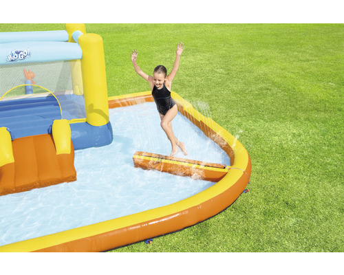 Aufblasbare Hüpfburg mit Pool im Garten mit spielendem Kind