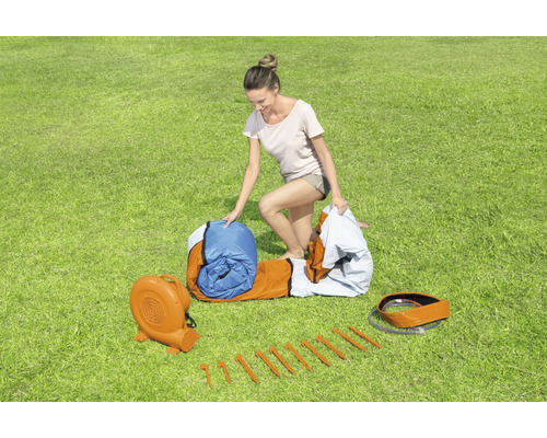 Aufblasbare Hüpfburg mit Gebläse, Heringen und Dame auf Rasen