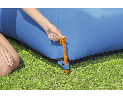 Detailansicht eines Erdnagels zur Befestigung eines blauen aufblasbaren Sofas im Garten.