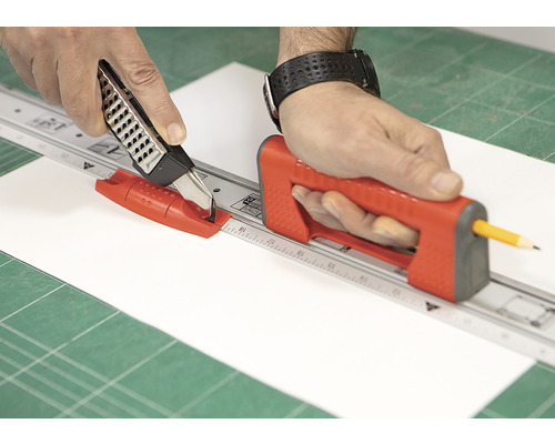 Personne coupant du papier avec un cutter rotatif et une règle à découper