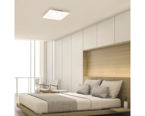 Quadratische Deckenleuchte in einem hellen Schlafzimmer mit Doppelbett