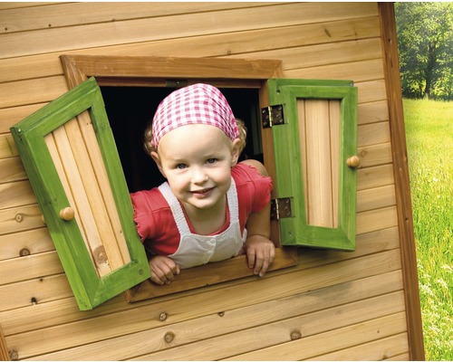 Kind schaut aus dem Fenster eines Holzspielhauses