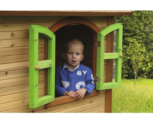 Enfant regardant par la fenêtre d''une cabane en bois