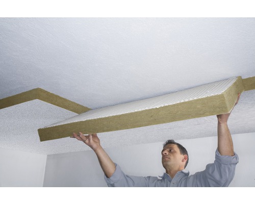 Un homme fixe des panneaux d''isolation de plafond au plafond