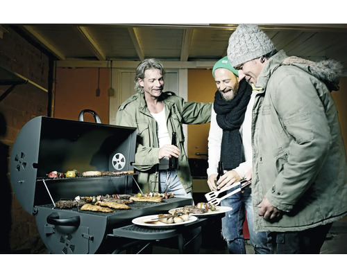 Trois hommes se tiennent autour d''un barbecue avec de la viande, des légumes et des brochettes.