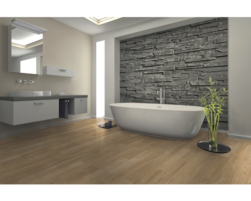 Modernes Badezimmer mit Badewanne, Waschtisch und Steinwand