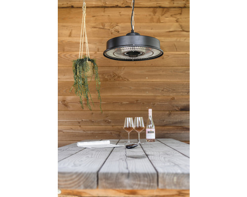 Szene mit Heizstrahler, Tisch, zwei Gläsern und einer Flasche