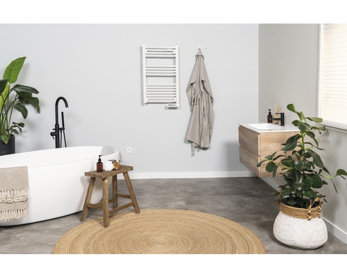 Salle de bain avec baignoire îlot, lavabo et sèche-serviettes