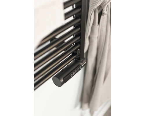 Gros plan d''un sèche-serviettes avec commande électronique et serviette