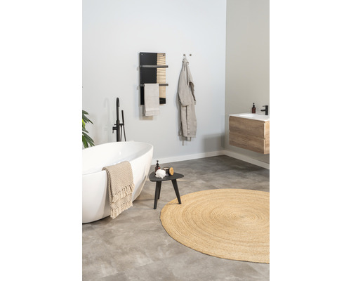 Salle de bain avec baignoire îlot, sèche-serviettes, tabouret et tapis rond