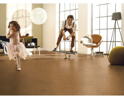 Familie spielt auf Korkboden in einem hellen Wohnzimmer.